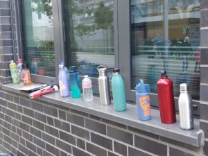 Trinkflaschen auf einer Fensterbank.