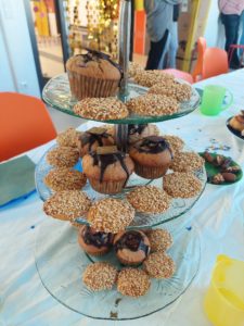 Dreigeschossige Etagere aus Glas mit Muffins und Semsagebäck. Die Etagere steht auf der Langen Tafel. 