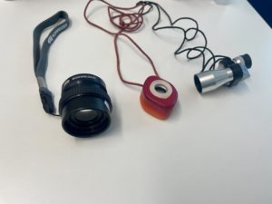 Ein schwarzes, rotes und silbernes verschieden aufgebautes Monokulare. Sehen aus wie Fernrohre. 